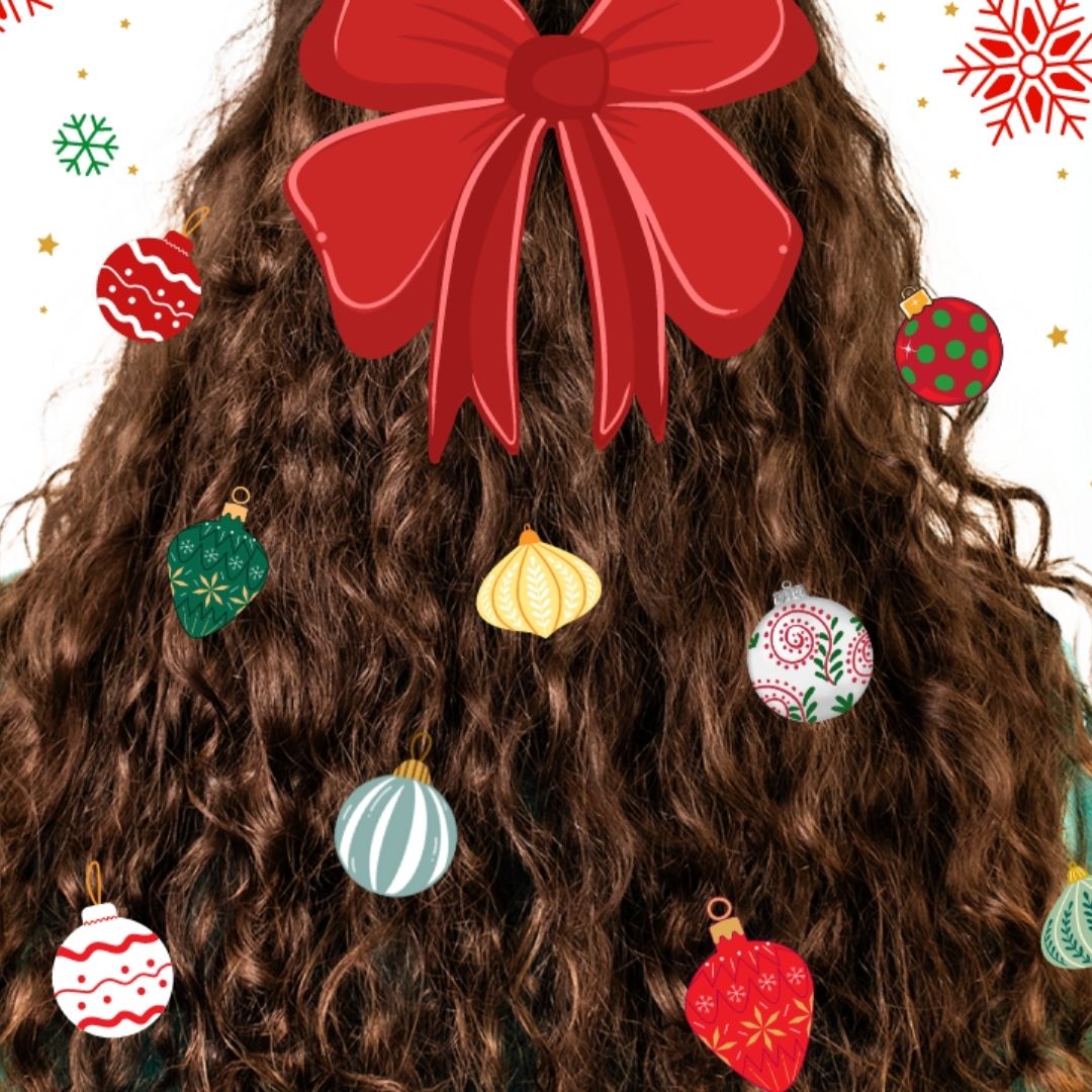 back of curly haired woman's head with multicolored ornaments in her hair and a red bow at the tope with a patterened background