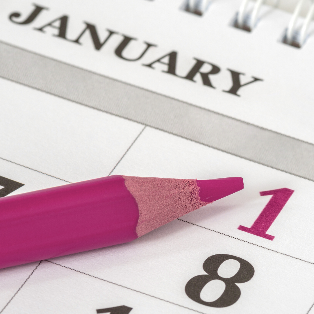 a close up of a calendar on the date January 1 with a pink colored pencil pointing at the 1