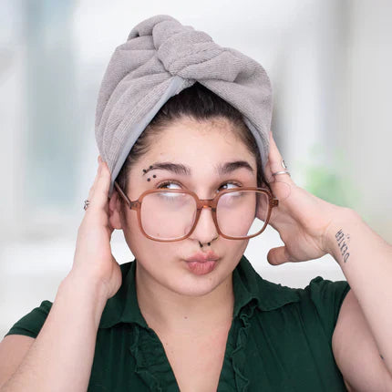 curly haired woman with her hair in a microfiber towel
