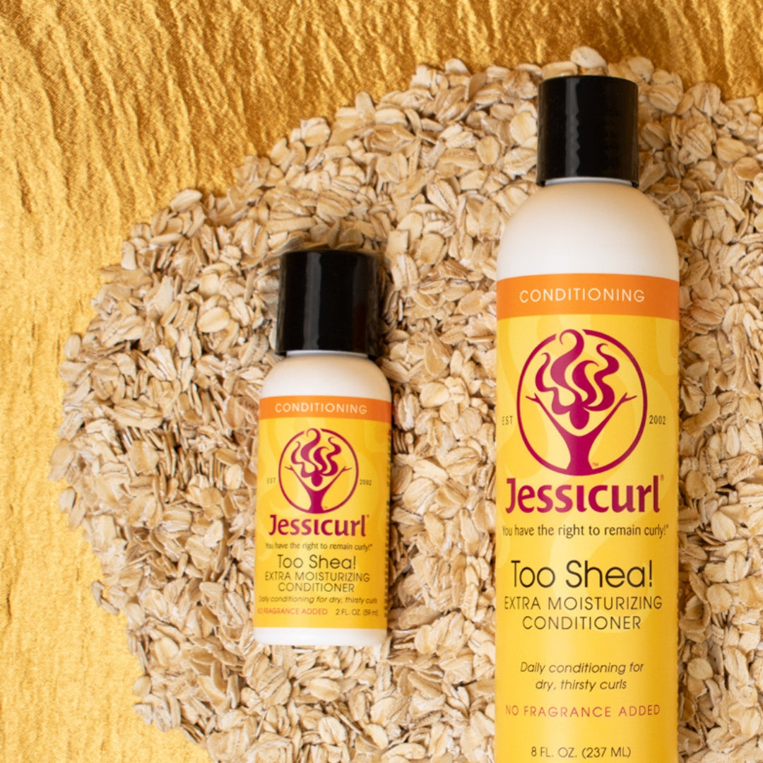two sized bottles of Too Shea! Extra Moisturizing Conditioner laying in a pile of oats