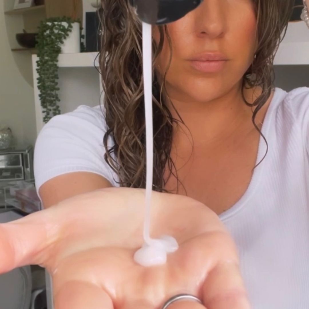 Chief Educator Claire pouring Spiralicious Styling Gel into her hand for her hair routine