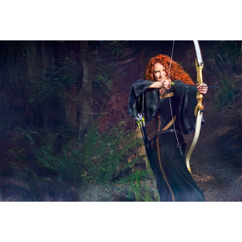 jessicurl founder, Jess McGuinty, dressed as Merida from Brave in a green dress and bow standing in a forrest