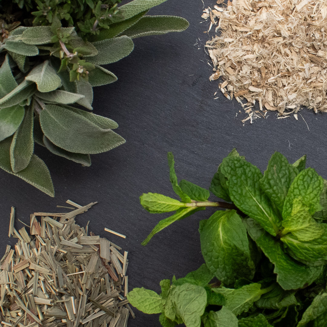 various herbs in piles on a gray slate table
